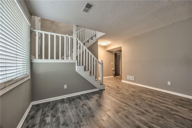 14033 Dornoch St, Grandview, MO 64030 - staircase featuring wood finished floors, a textured ceiling, and baseboards