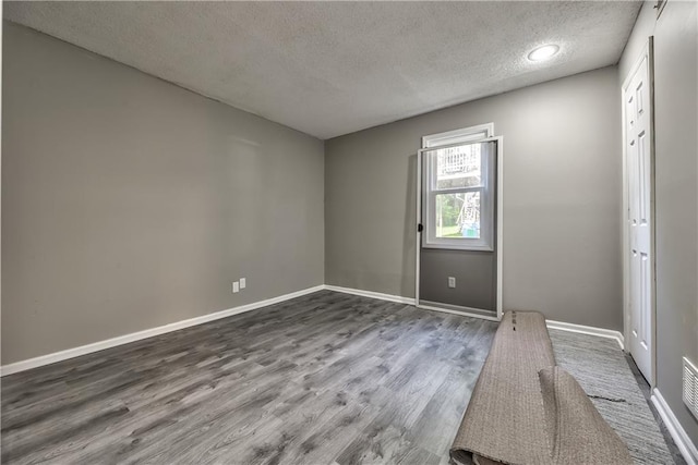 14033 Dornoch St, Grandview, MO 64030 - spare room featuring a textured ceiling, dark wood finished floors, and baseboards