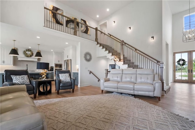 15318 W 172nd Pl, Olathe, KS 66062 - living area with a towering ceiling, light wood-style floors, stairs, a chandelier, and recessed lighting