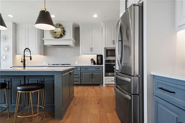 15318 W 172nd Pl, Olathe, KS 66062 - kitchen featuring appliances with stainless steel finishes, decorative backsplash, light countertops, a breakfast bar area, and white cabinetry