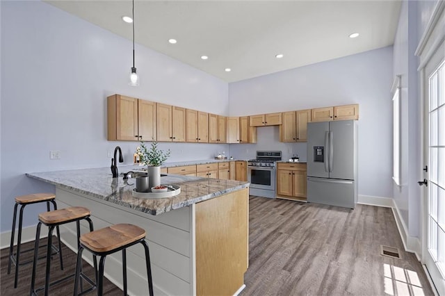 1003 Commercial St, Atchison, KS 66002 - kitchen featuring appliances with stainless steel finishes, high vaulted ceiling, a sink, baseboards, and a peninsula