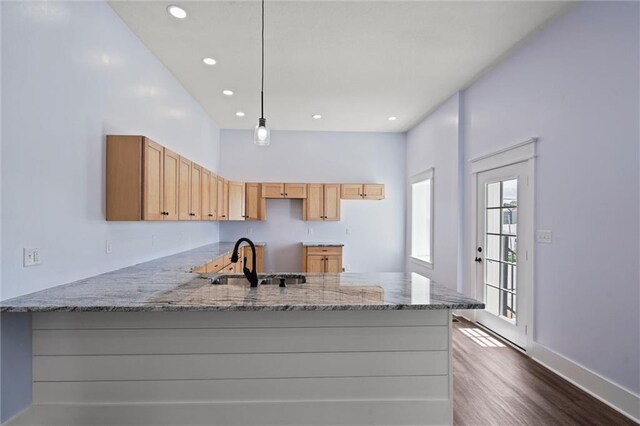 1003 Commercial St, Atchison, KS 66002 - kitchen featuring a sink, a peninsula, light stone counters, dark wood-style floors, and recessed lighting