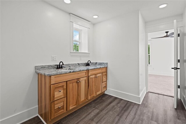 1003 Commercial St, Atchison, KS 66002 - bathroom featuring wood finished floors, baseboards, double vanity, and recessed lighting