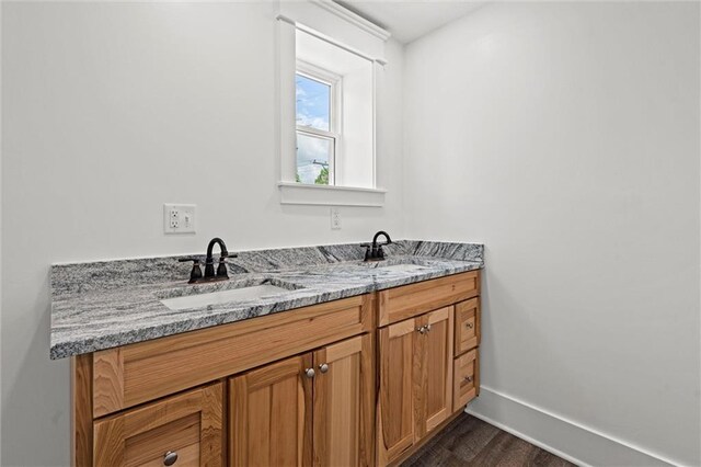 1003 Commercial St, Atchison, KS 66002 - bathroom with wood finished floors, double vanity, and baseboards
