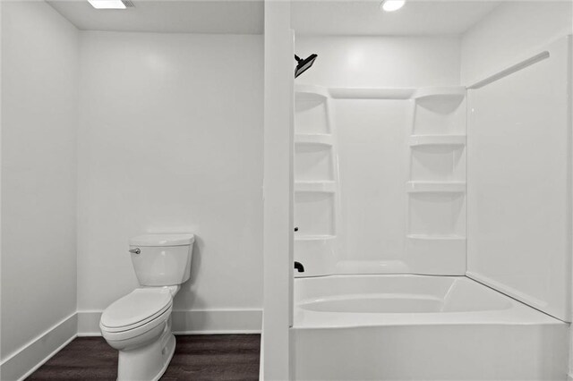 1003 Commercial St, Atchison, KS 66002 - bathroom featuring baseboards, toilet, shower / bathtub combination, and wood finished floors