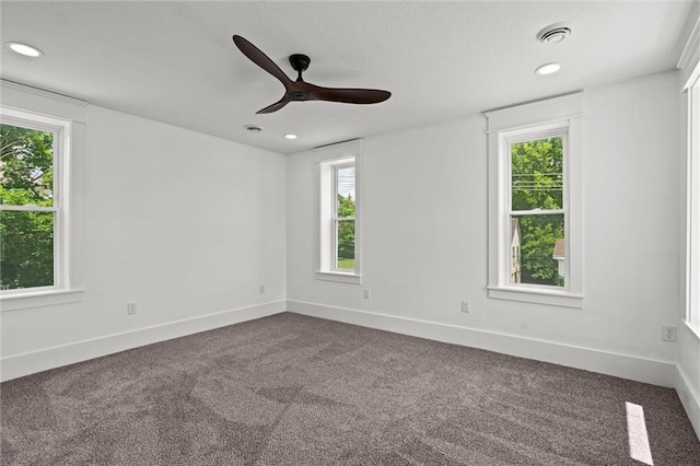1003 Commercial St, Atchison, KS 66002 - empty room with healthy amount of natural light, dark carpet, ceiling fan, and recessed lighting