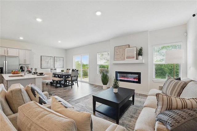 7708 NE 107th Ter, Kansas City, MO 64157 - living area with plenty of natural light, light wood-style floors, a glass covered fireplace, recessed lighting, and baseboards