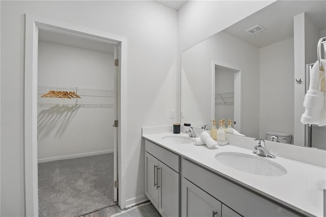 7708 NE 107th Ter, Kansas City, MO 64157 - bathroom with double vanity, a spacious closet, and toilet