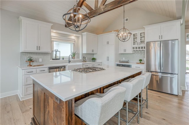 17162 S Hall St, Olathe, KS 66062 - kitchen with appliances with stainless steel finishes, a chandelier, a sink, a kitchen island, and lofted ceiling