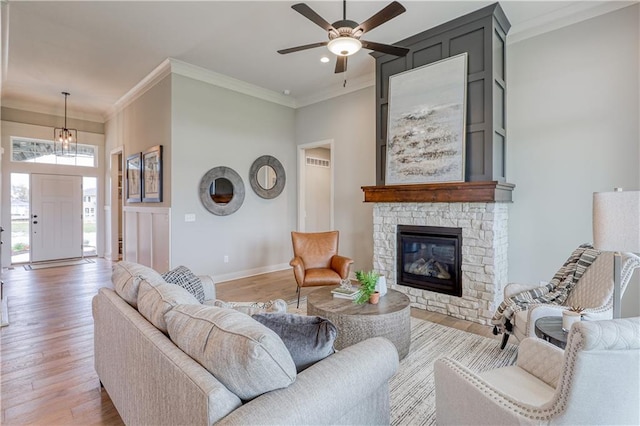 17162 S Hall St, Olathe, KS 66062 - living area featuring light wood-type flooring, ornamental molding, a ceiling fan, a stone fireplace, and baseboards