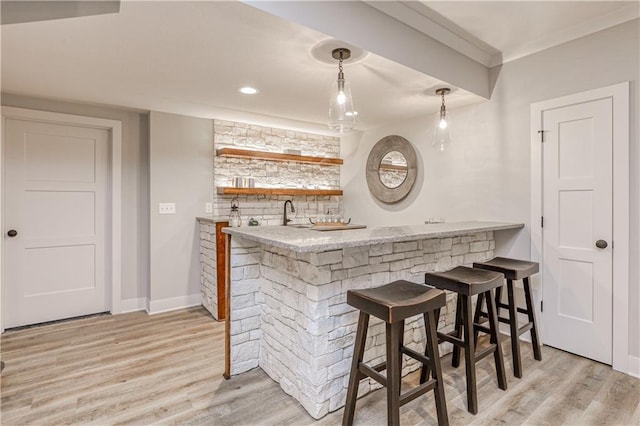 17162 S Hall St, Olathe, KS 66062 - indoor wet bar with light wood-style flooring, baseboards, ornamental molding, hanging light fixtures, and recessed lighting
