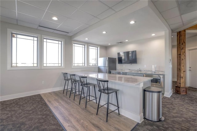 17162 S Hall St, Olathe, KS 66062 - kitchen with freestanding refrigerator, a breakfast bar, wall oven, a sink, and a peninsula