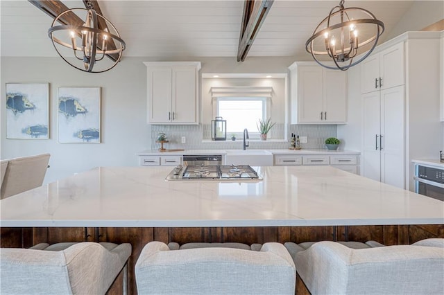 17162 S Hall St, Olathe, KS 66062 - kitchen with a chandelier, a sink, a large island, white cabinetry, and beamed ceiling