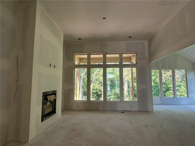 17162 S Hall St, Olathe, KS 66062 - unfurnished living room with a textured ceiling and a tile fireplace