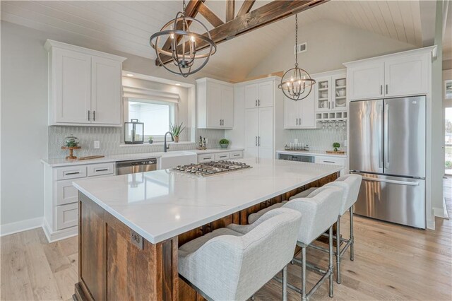 17162 S Hall St, Olathe, KS 66062 - kitchen with appliances with stainless steel finishes, a chandelier, a center island, white cabinetry, and vaulted ceiling