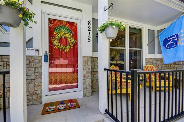8215 W 150th St, Overland Park, KS 66223 - doorway to property with stone siding and a porch