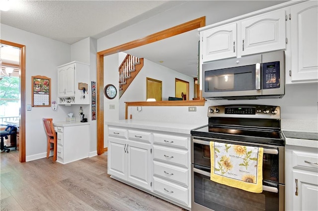 8215 W 150th St, Overland Park, KS 66223 - kitchen with appliances with stainless steel finishes, light wood-type flooring, light countertops, white cabinets, and a textured ceiling