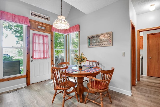 8215 W 150th St, Overland Park, KS 66223 - dining space with wood finished floors, a chandelier, baseboards, and vaulted ceiling