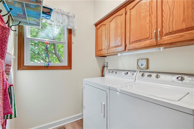 8215 W 150th St, Overland Park, KS 66223 - laundry room with washer and clothes dryer, cabinet space, baseboards, and light wood-style flooring