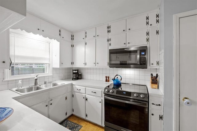 607 E 110th St, Kansas City, MO 64131 - kitchen featuring electric stove, a sink, light countertops, and white cabinets