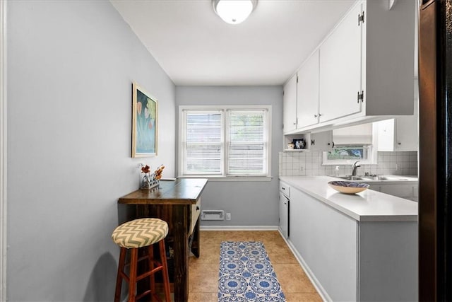 607 E 110th St, Kansas City, MO 64131 - laundry room featuring a sink, light tile patterned flooring, and baseboards
