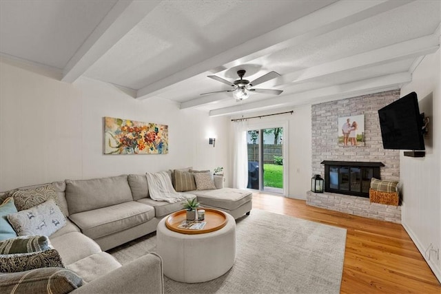 607 E 110th St, Kansas City, MO 64131 - living area featuring wood finished floors, beamed ceiling, ceiling fan, and a fireplace