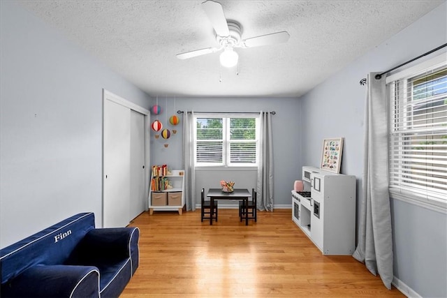 607 E 110th St, Kansas City, MO 64131 - game room featuring light wood-type flooring, a textured ceiling, and a ceiling fan