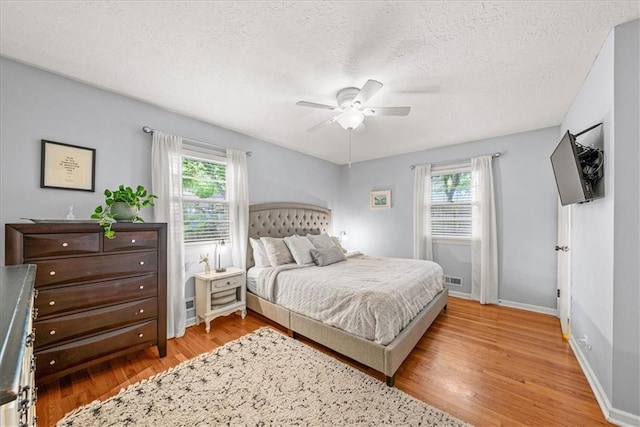 607 E 110th St, Kansas City, MO 64131 - bedroom with multiple windows, light wood-type flooring, a textured ceiling, baseboards, and ceiling fan