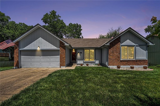 7816 Garnett St, Lenexa, KS 66214 - ranch-style house featuring driveway, a lawn, a garage, and brick siding
