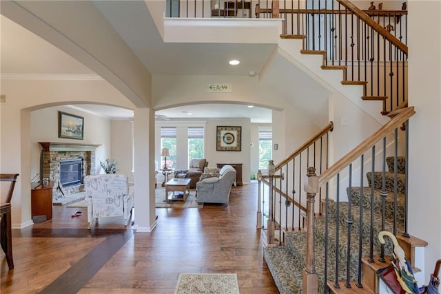 25005 W 85th Ter, Lenexa, KS 66227 - foyer with a fireplace, wood finished floors, arched walkways, stairs, and ornamental molding