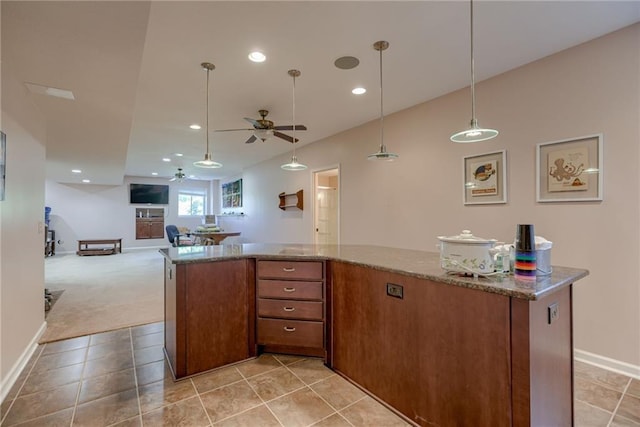 25005 W 85th Ter, Lenexa, KS 66227 - kitchen featuring a ceiling fan, open floor plan, brown cabinetry, stone counters, and light colored carpet