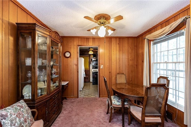 6038 Catalina St, Fairway, KS 66205 - carpeted dining room featuring a ceiling fan, wood walls, a textured ceiling, and crown molding