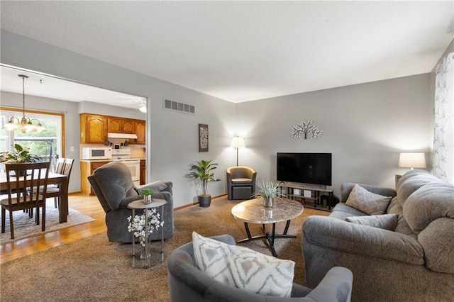 215 SE Country Ln, Lees Summit, MO 64063 - living room featuring a chandelier, light wood-style flooring, and baseboards