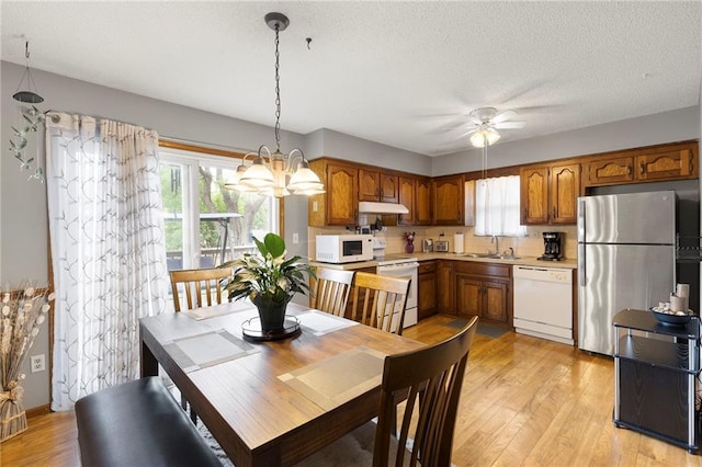 215 SE Country Ln, Lees Summit, MO 64063 - dining room featuring a ceiling fan, light wood-type flooring, a chandelier, and a textured ceiling