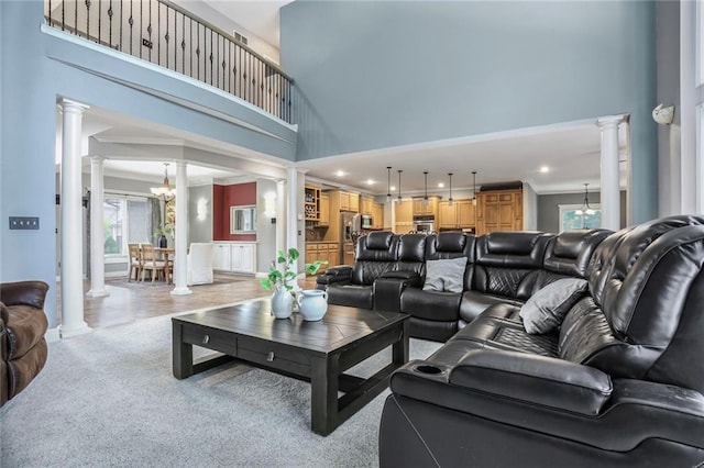 13808 Richards St, Overland Park, KS 66221 - living area featuring ornate columns, a high ceiling, recessed lighting, light colored carpet, and a chandelier