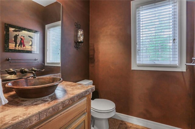 13808 Richards St, Overland Park, KS 66221 - half bathroom featuring toilet, vanity, baseboards, and tile patterned floors