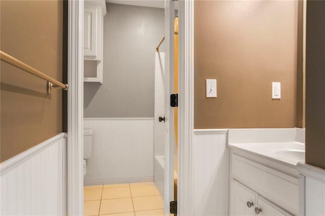13808 Richards St, Overland Park, KS 66221 - full bathroom with a wainscoted wall, vanity, toilet, tile patterned flooring, and  shower combination