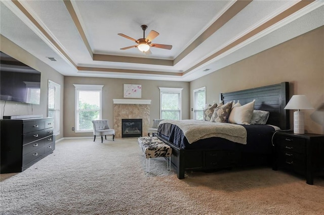 13808 Richards St, Overland Park, KS 66221 - carpeted bedroom featuring a raised ceiling, a tiled fireplace, crown molding, and a ceiling fan