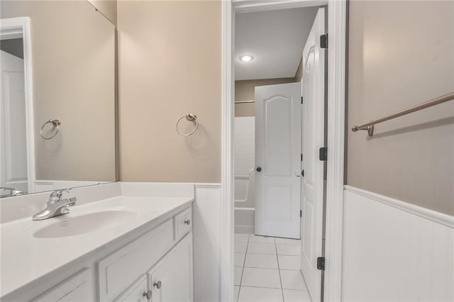 13808 Richards St, Overland Park, KS 66221 - bathroom featuring a wainscoted wall, vanity, tile patterned floors, and shower / bathtub combination