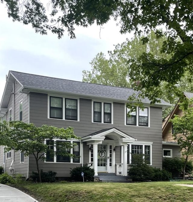 6427 Wyandotte St, Kansas City, MO 64113 - colonial house featuring a front lawn and roof with shingles