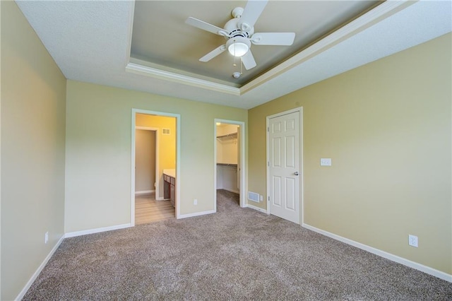 8815 Timber Creek Ln, Pleasant Valley, MO 64068 - unfurnished bedroom featuring light carpet, a raised ceiling, a walk in closet, baseboards, and a closet