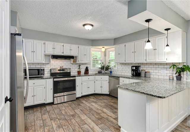 530 Nipper Ln, Leavenworth, KS 66048 - kitchen with appliances with stainless steel finishes, under cabinet range hood, a peninsula, white cabinetry, and a textured ceiling