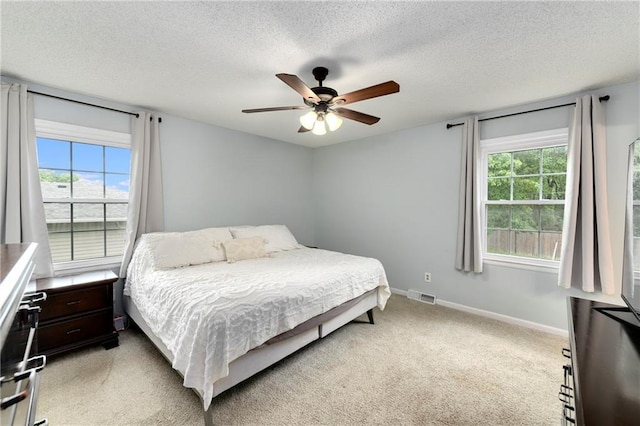 530 Nipper Ln, Leavenworth, KS 66048 - bedroom with multiple windows, light carpet, baseboards, a textured ceiling, and ceiling fan