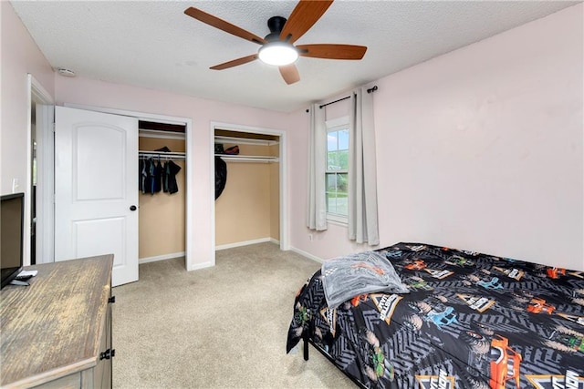 530 Nipper Ln, Leavenworth, KS 66048 - bedroom featuring two closets, carpet, a textured ceiling, ceiling fan, and baseboards
