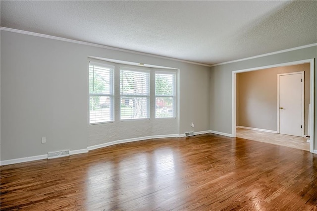 12800 W 100th St, Lenexa, KS 66215 - unfurnished room with a textured ceiling, crown molding, wood finished floors, and baseboards