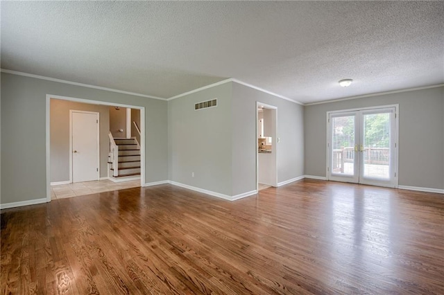 12800 W 100th St, Lenexa, KS 66215 - spare room featuring a textured ceiling, crown molding, wood finished floors, stairway, and baseboards