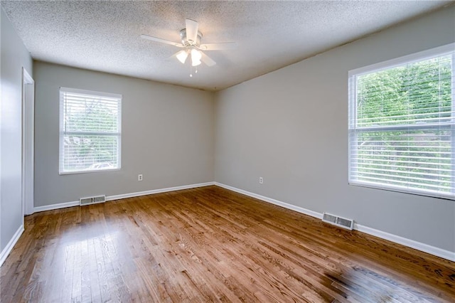 12800 W 100th St, Lenexa, KS 66215 - empty room with a ceiling fan, plenty of natural light, wood finished floors, and a textured ceiling