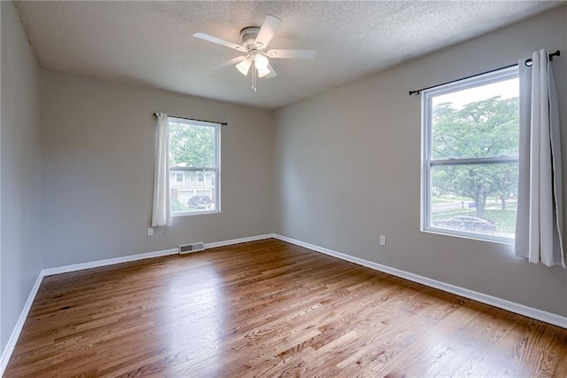 12800 W 100th St, Lenexa, KS 66215 - unfurnished room featuring wood finished floors, a textured ceiling, ceiling fan, and baseboards