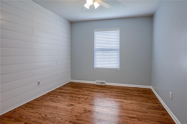 12800 W 100th St, Lenexa, KS 66215 - empty room featuring a ceiling fan, wood finished floors, a textured ceiling, and baseboards