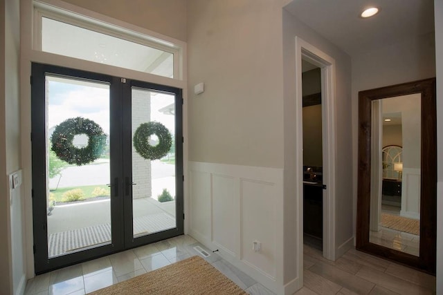 10300 W 174th St, Overland Park, KS 66221 - entryway with french doors, healthy amount of natural light, a wainscoted wall, and a decorative wall